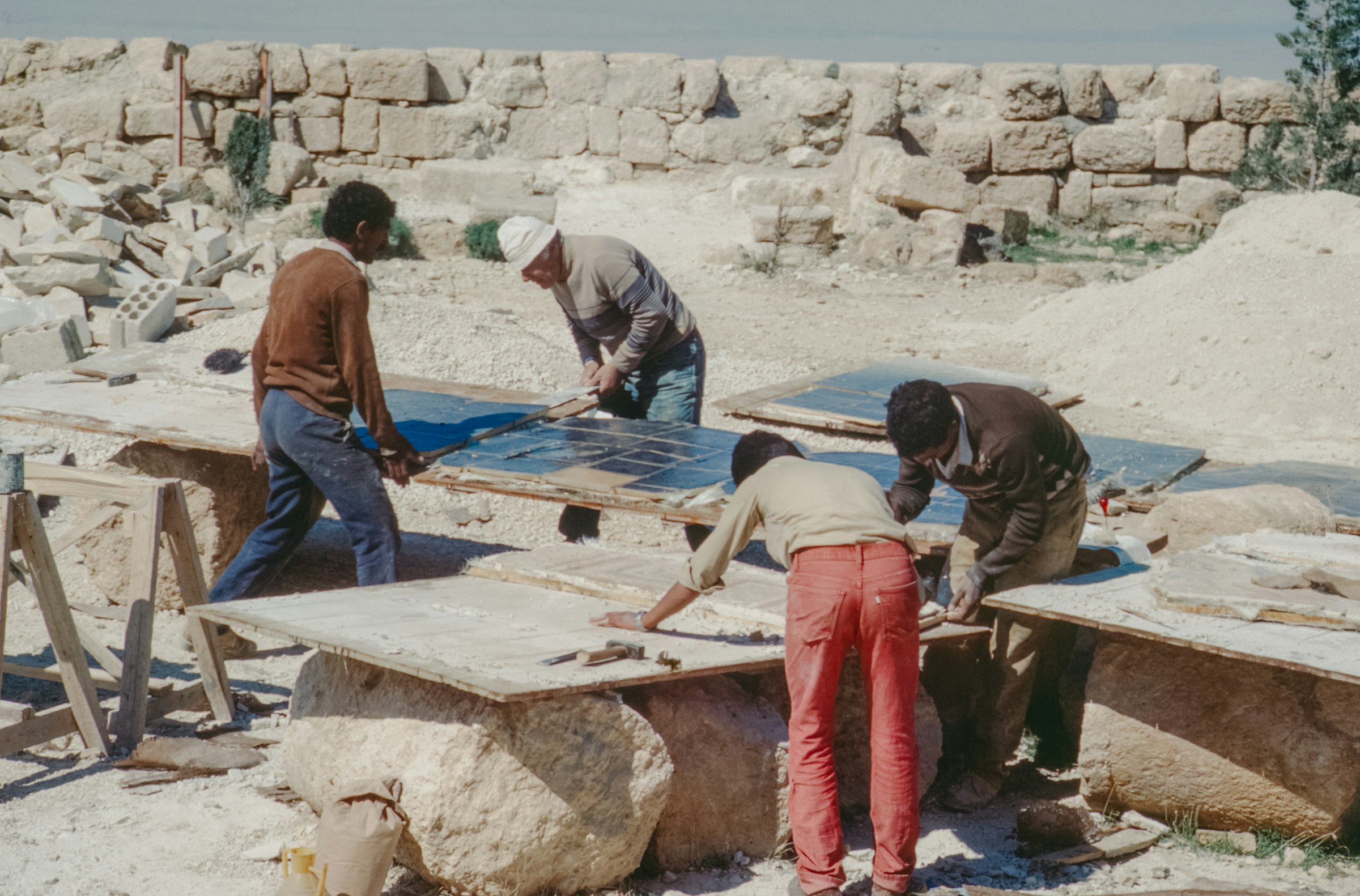 Craft workers polishing large stone slabs outdoors
